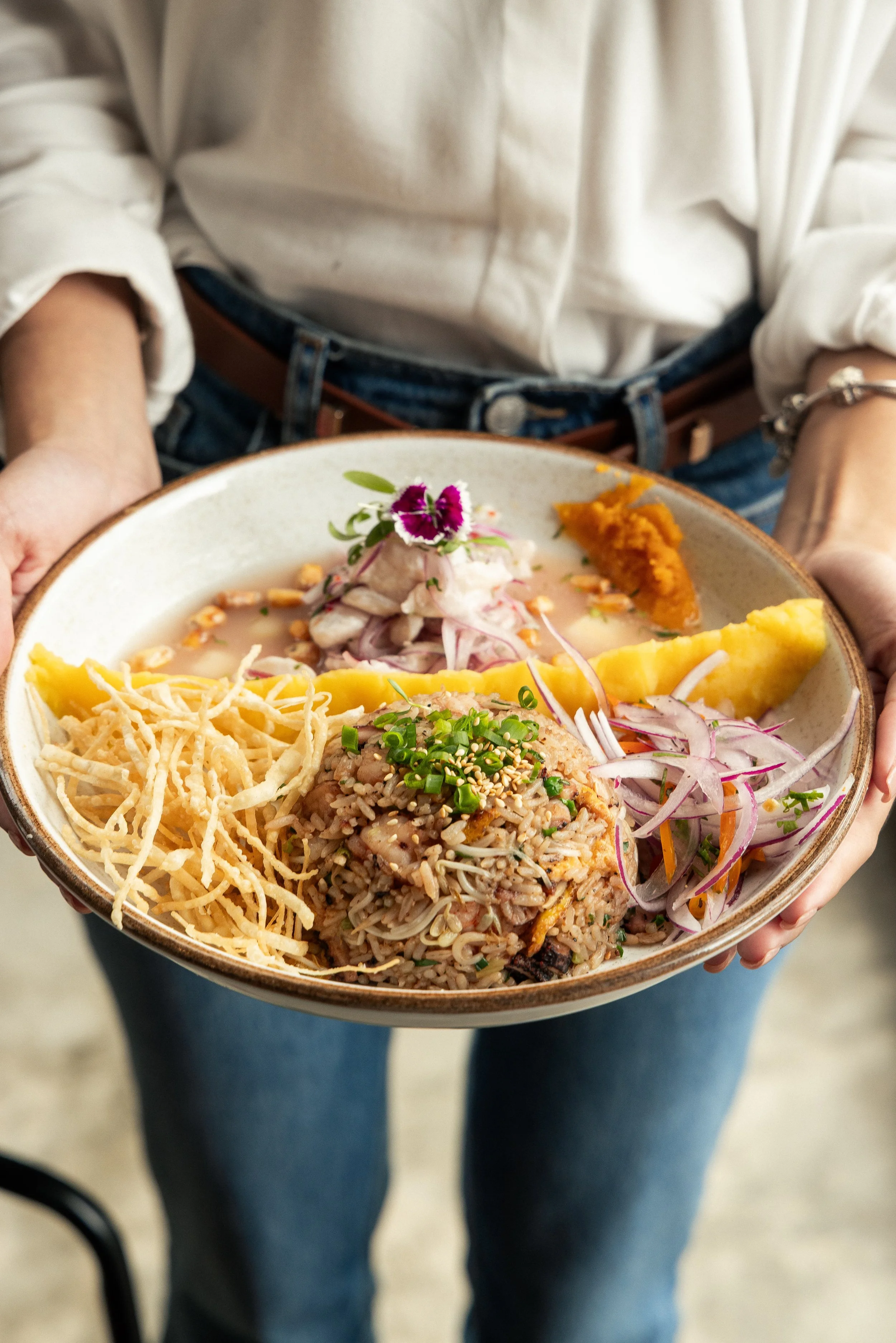Enkai fried rice bowl with crispy potato strips, vegetables and edible flowers.