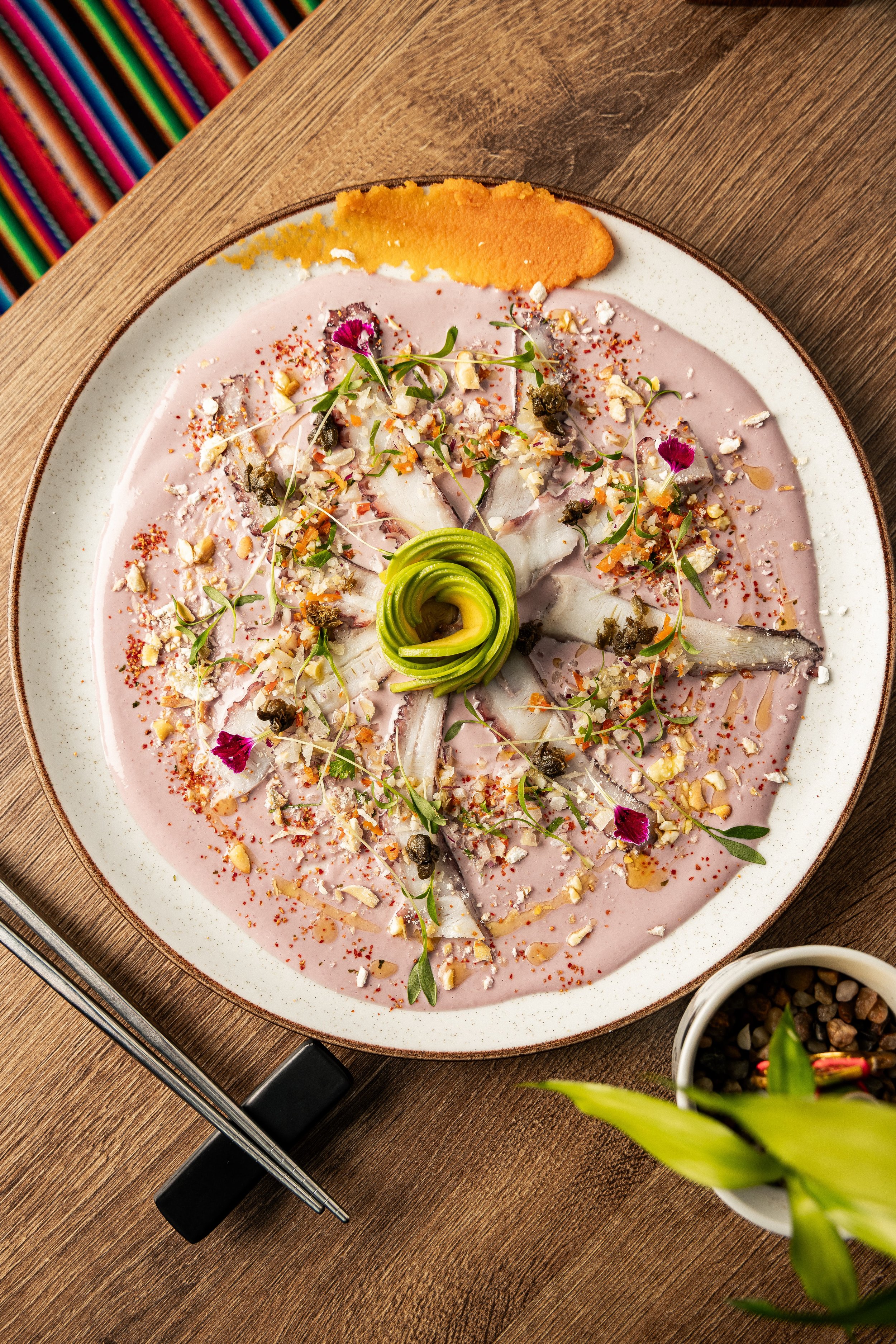 Nikkei tiradito with avocado rose, red onion and edible flowers at Enkai.