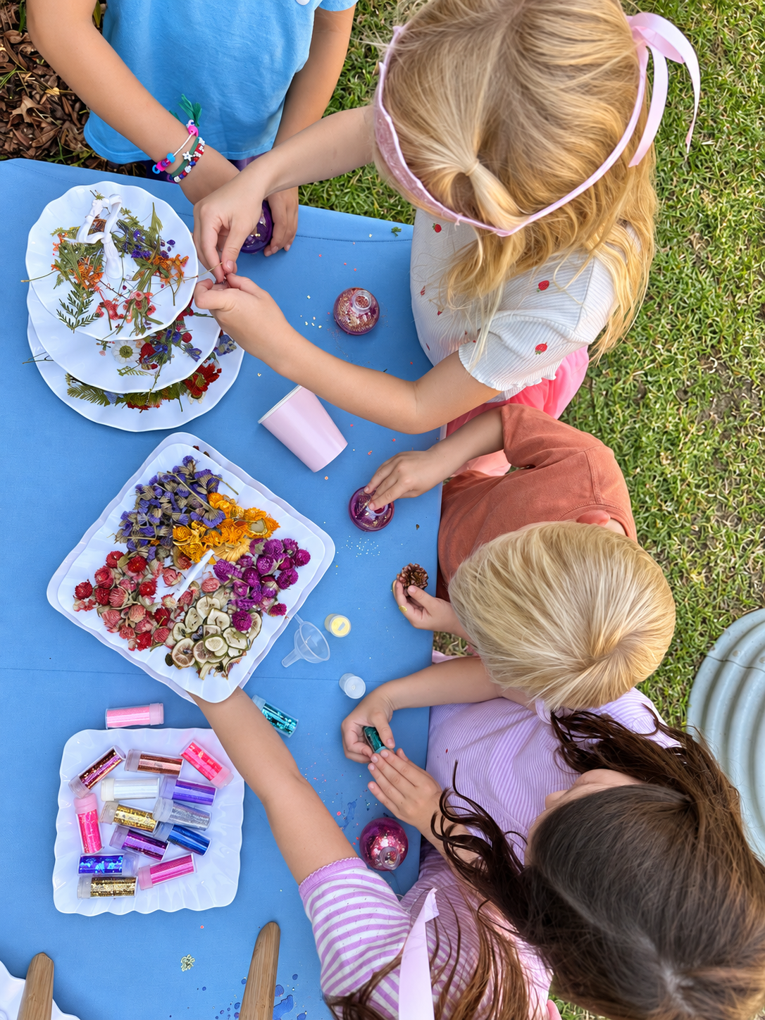 Children making flower-filled potions together at a garden party