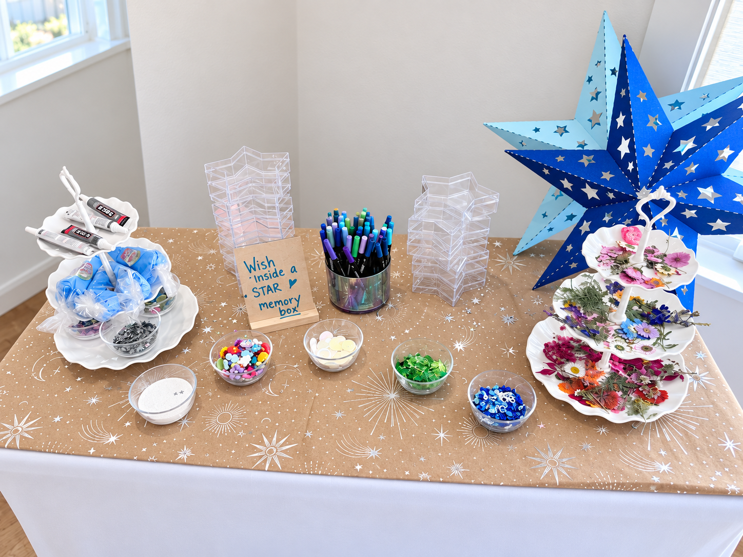 A star-themed memory-box activity table with colorful craft materials and keepsake boxes