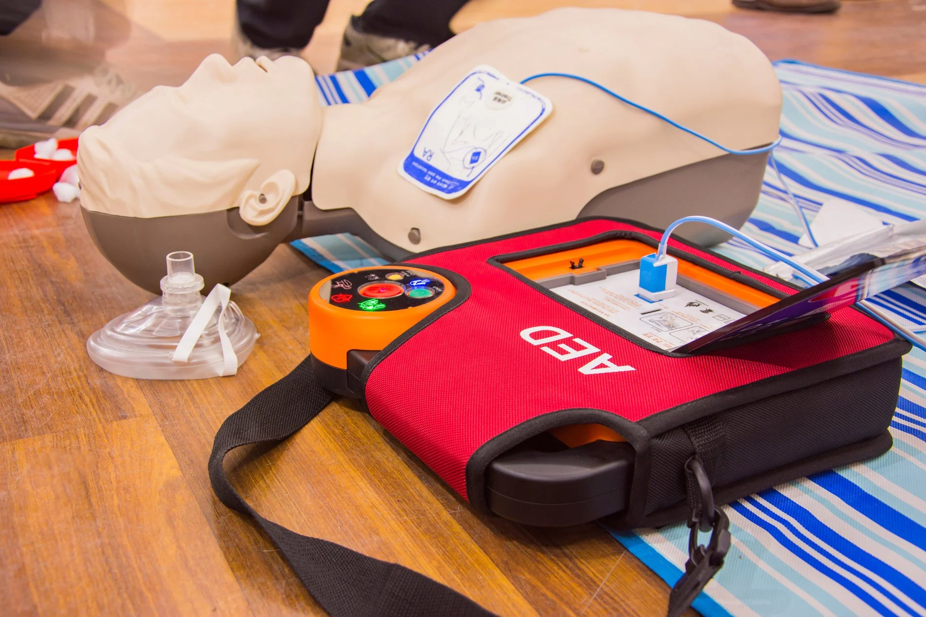 Instructor and student practicing BLS CPR with an AED during class