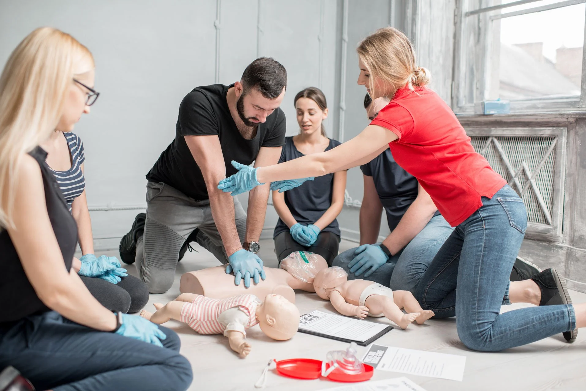 CPR training class with instructor and students practicing hands-on skills