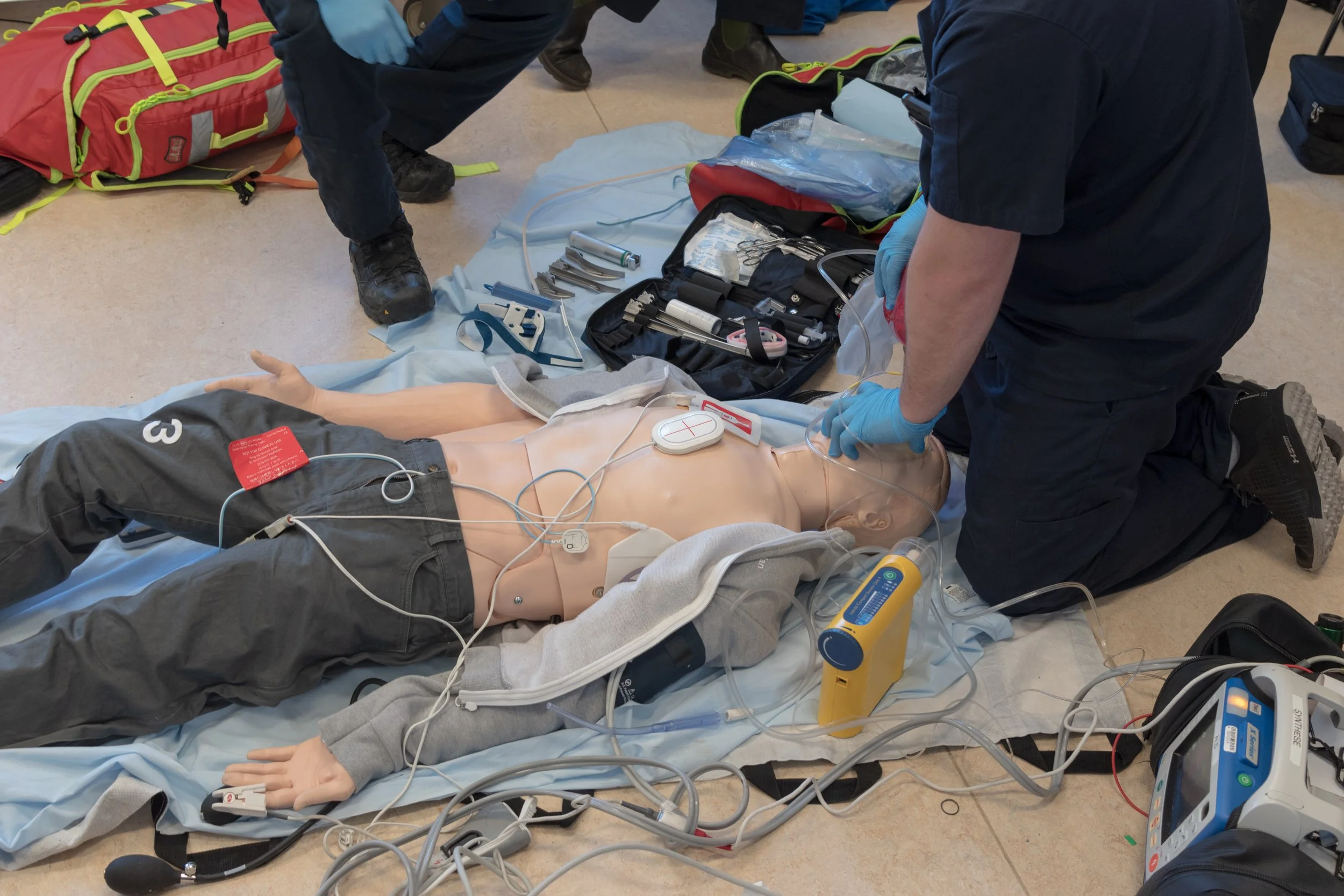 Instructor and student practicing BLS CPR with an AED during class