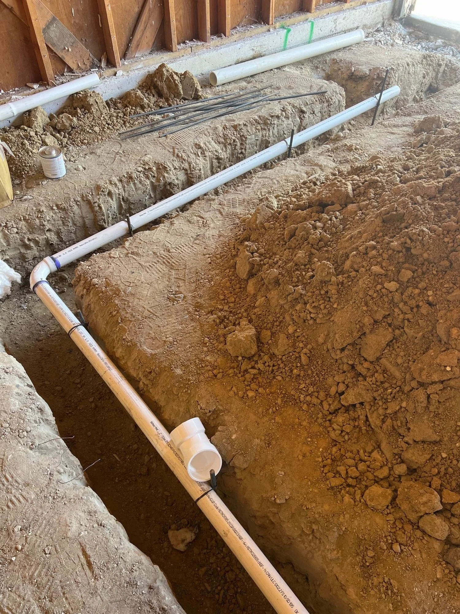 Underground drain line set in a trench below the floor