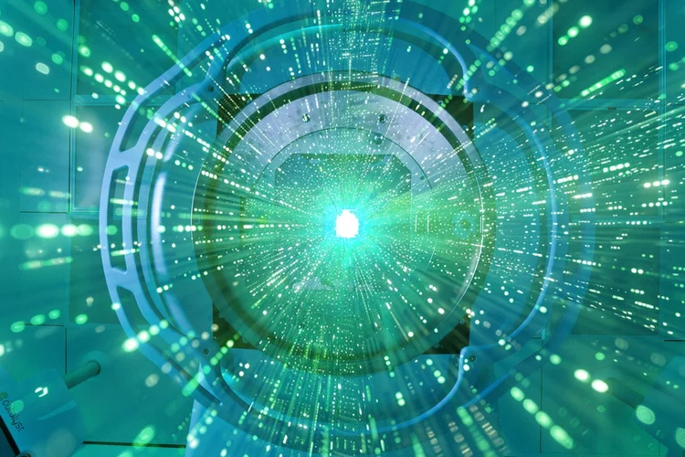 A radiotherapy machine with a teal beam and data visualisation.