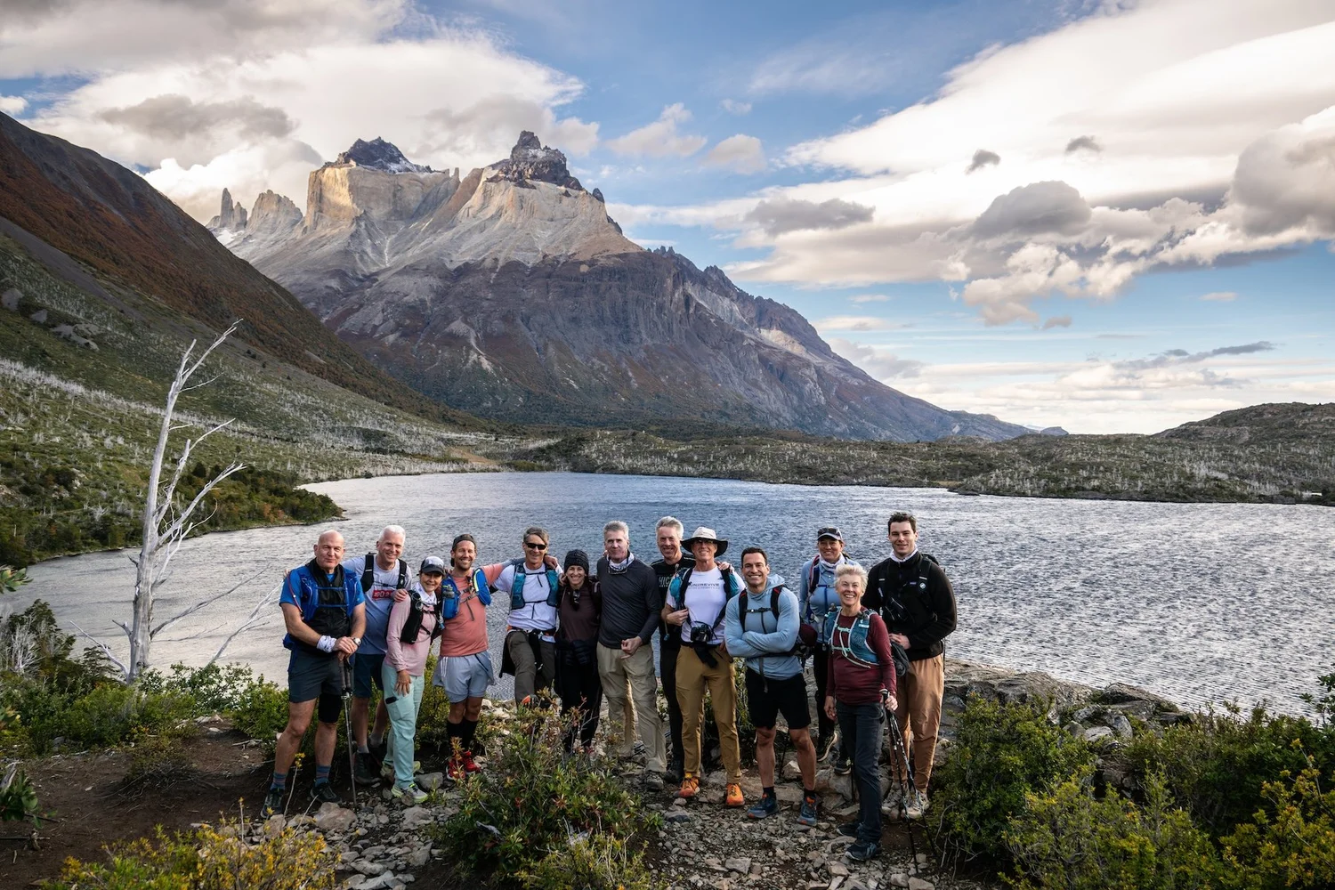 The group gathered at the lake with the Cuernos behind