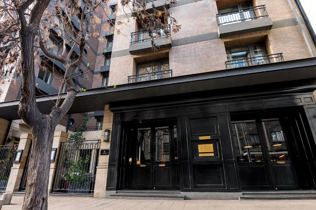 The hotel facade on a leafy Lastarria street