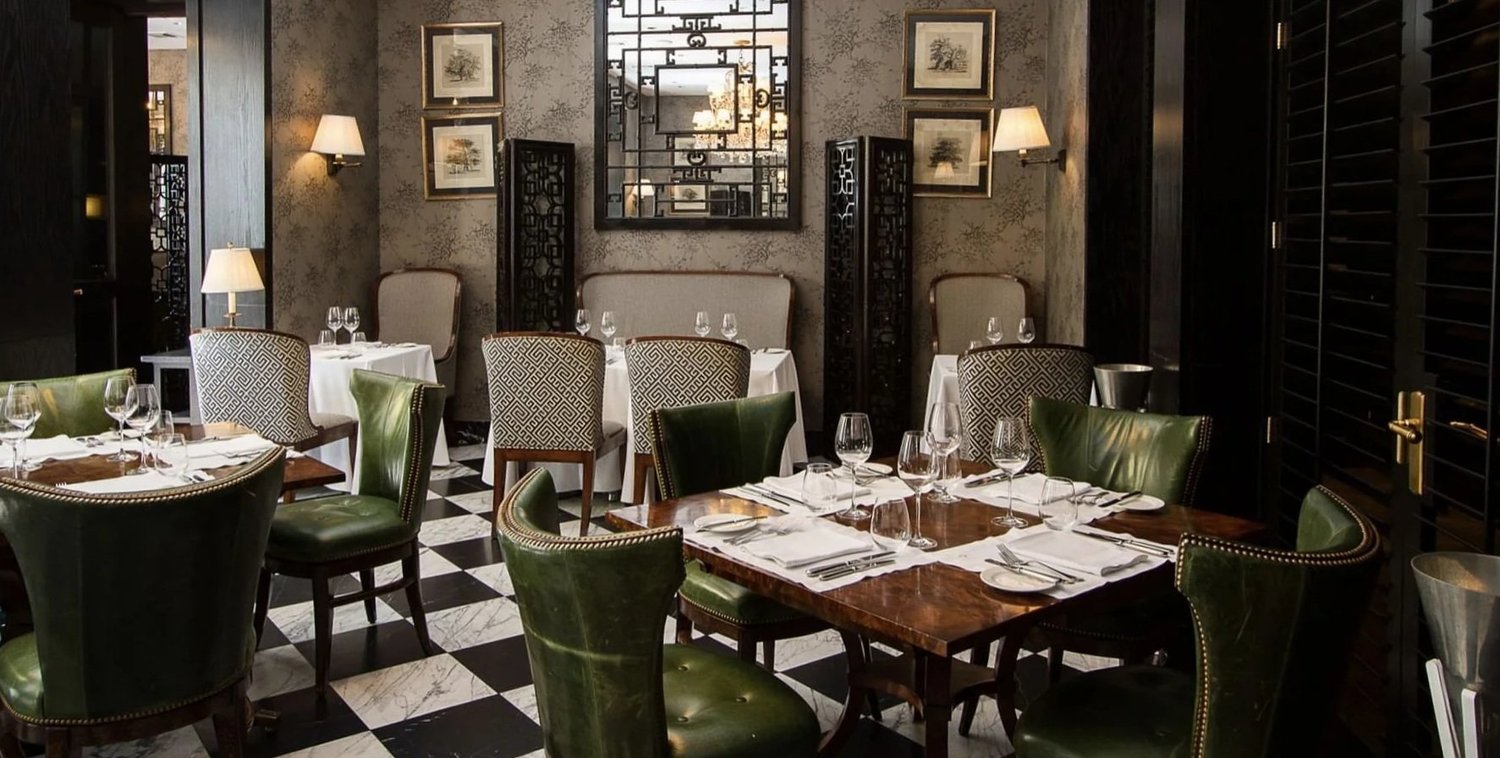 The hotel dining room, chequerboard marble and green leather