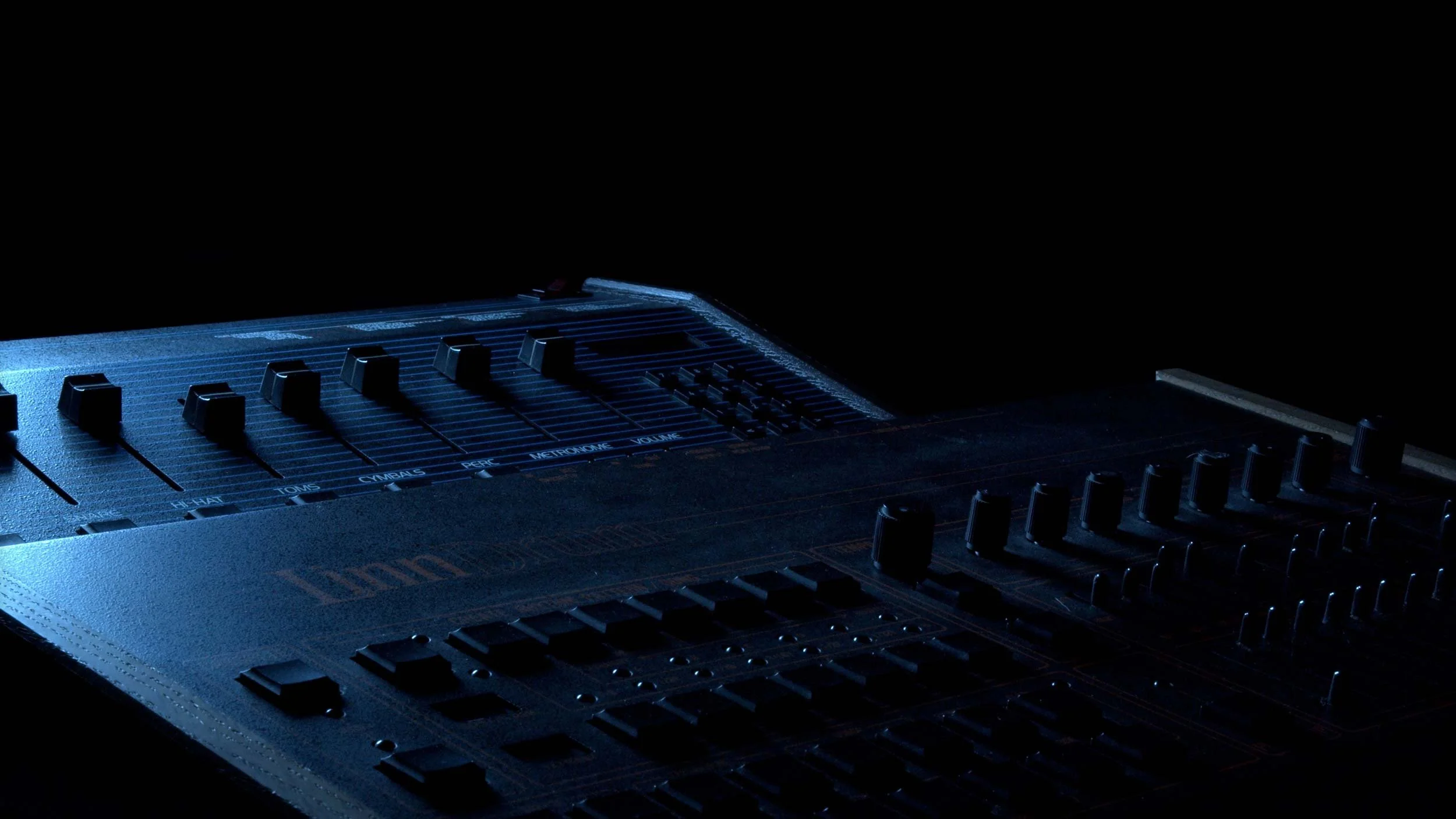 Vintage Linn and Oberheim drum machines in blue light