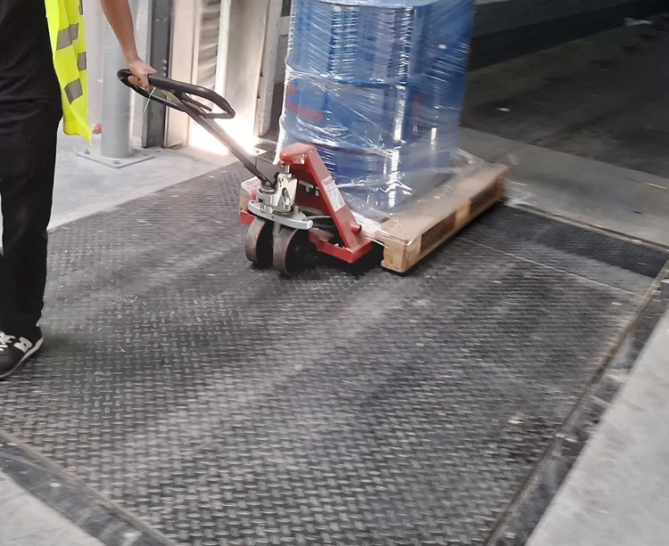 Een duale leerling trekt een pallet met een transpallet