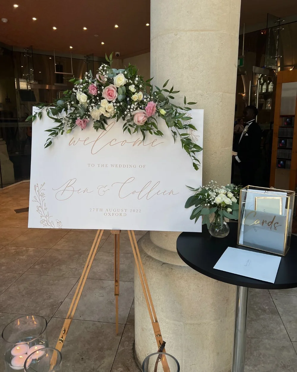 Ben and Colleen’s wedding welcome sign decorated with pink and white flowers.