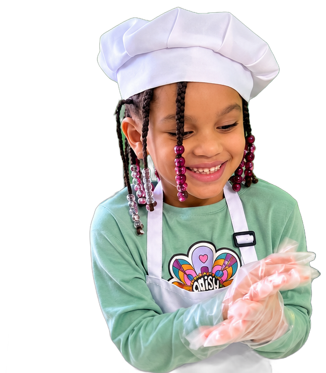 A smiling girl in a chef's hat and apron at TRAC's cooking class
