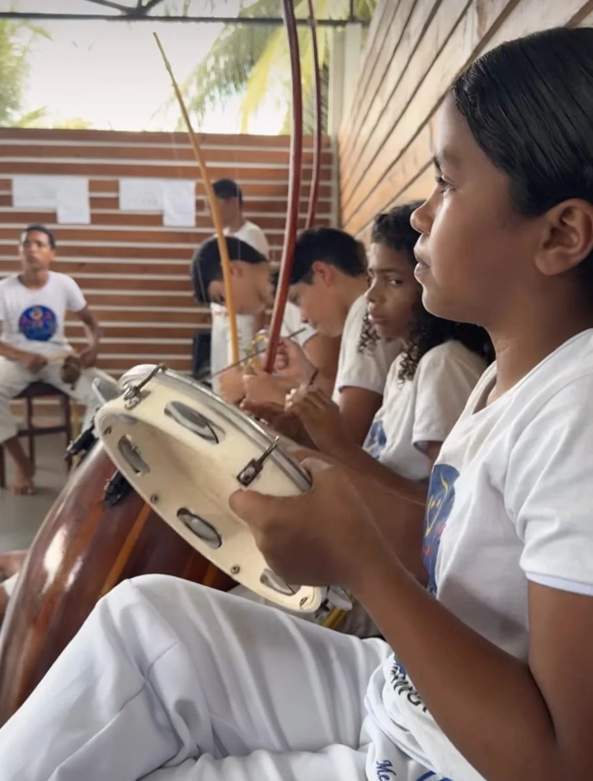 Kinder musizieren bei Anajô gemeinsam mit Pandeiro, Berimbau und Trommel.
