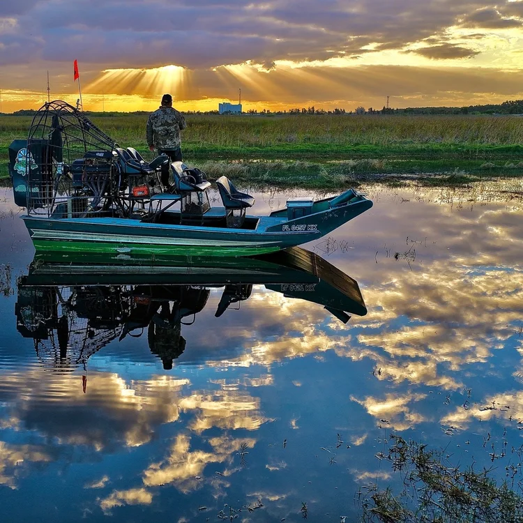 Private airboat reflected in Everglades water at sunrise