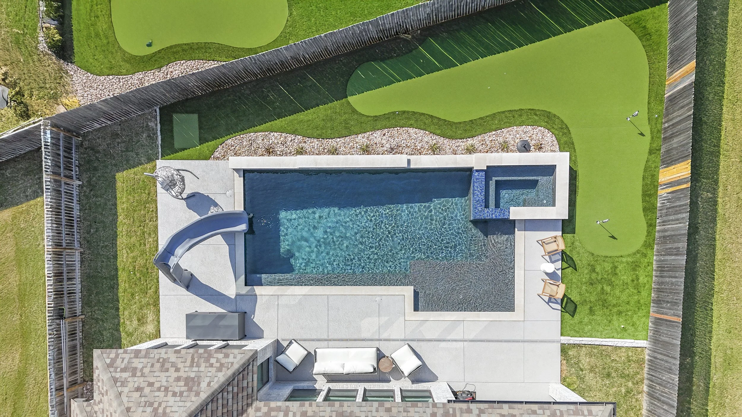 Aerial view of custom gunite pool and spa with premium decking and outdoor living area