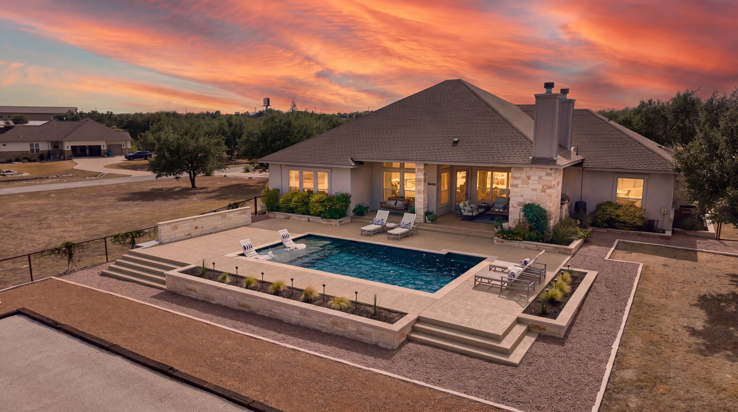 Wide sunset view of custom pool — Spicewood, TX