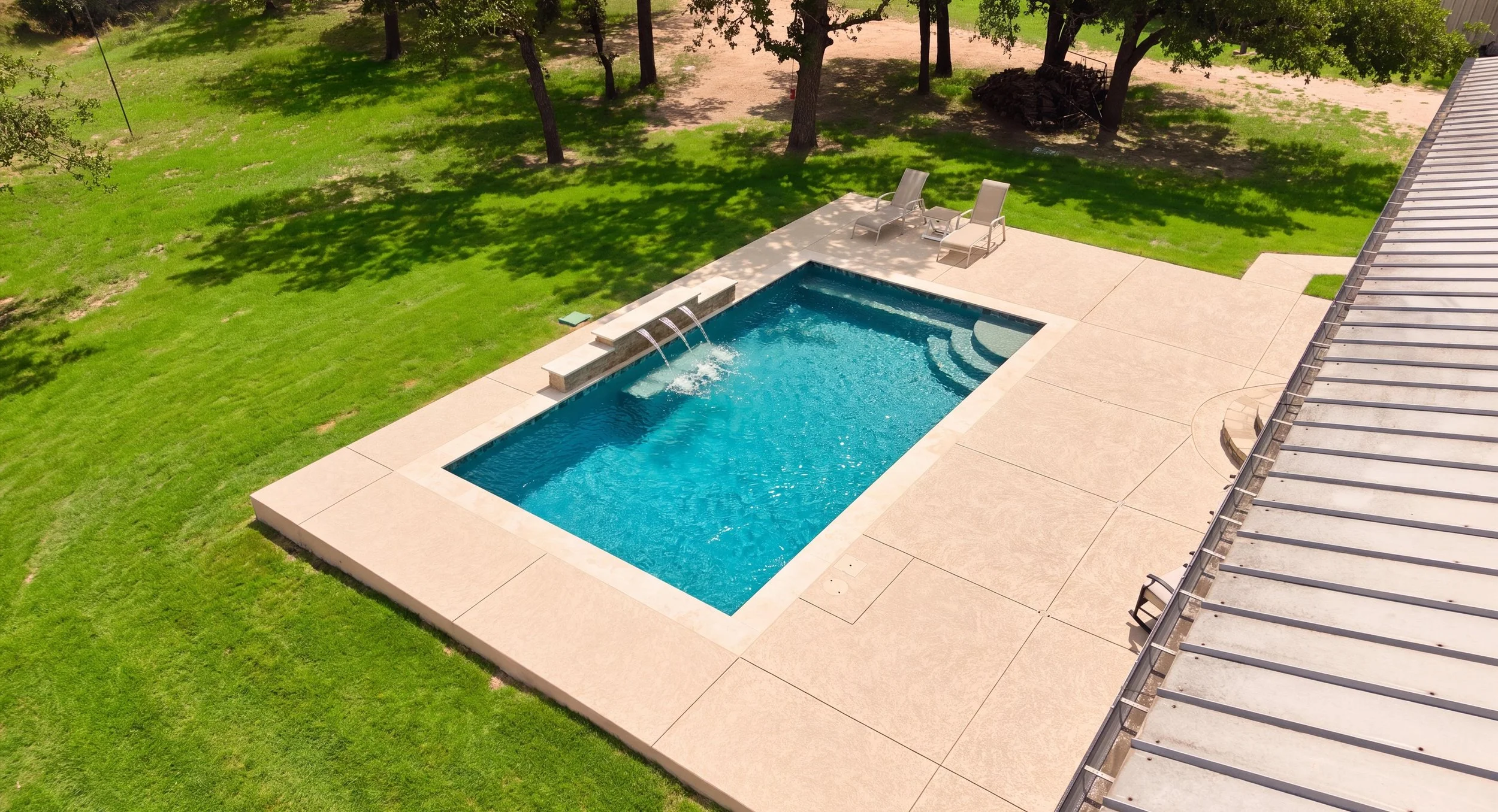 Angled aerial view of pool and raised bond beam wall — Kingsland TX