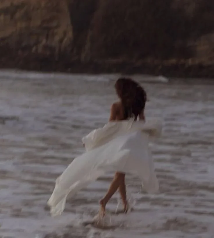 Woman walking beside the water