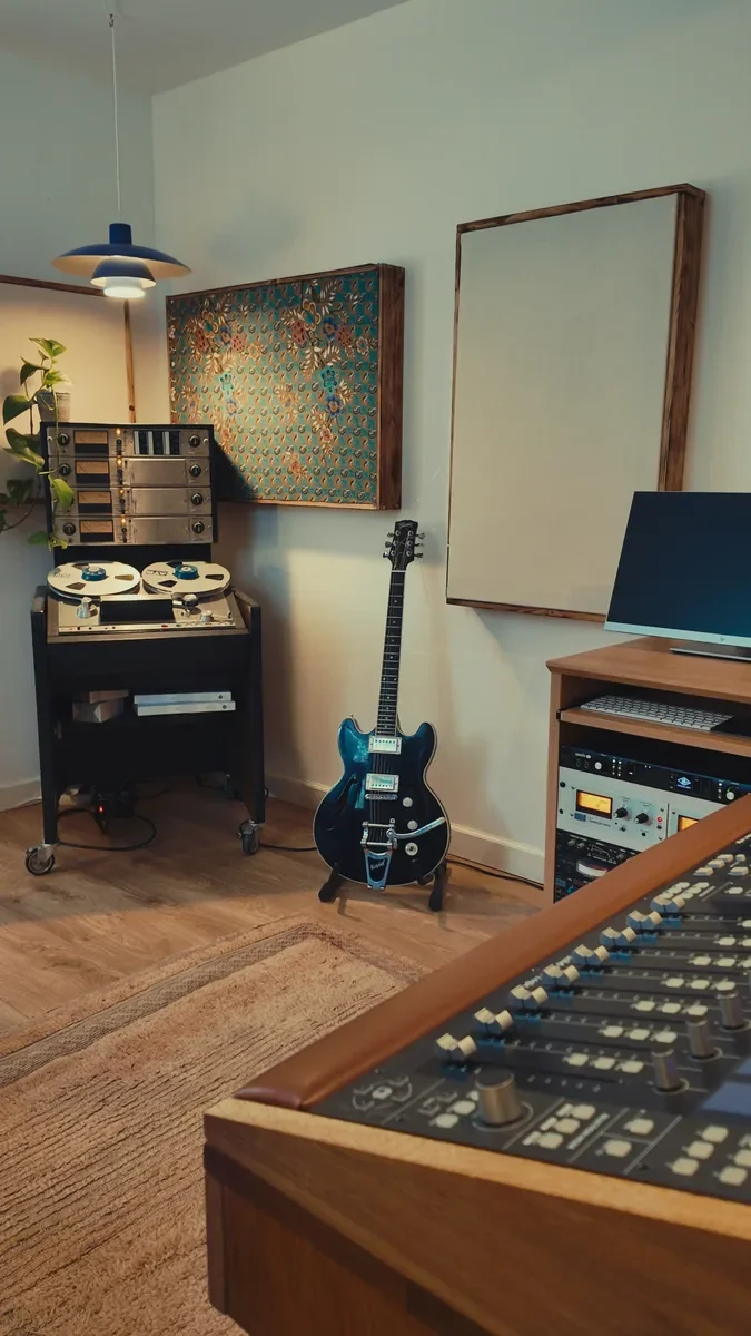 The opposite wall with tape machine, guitar and mixing console