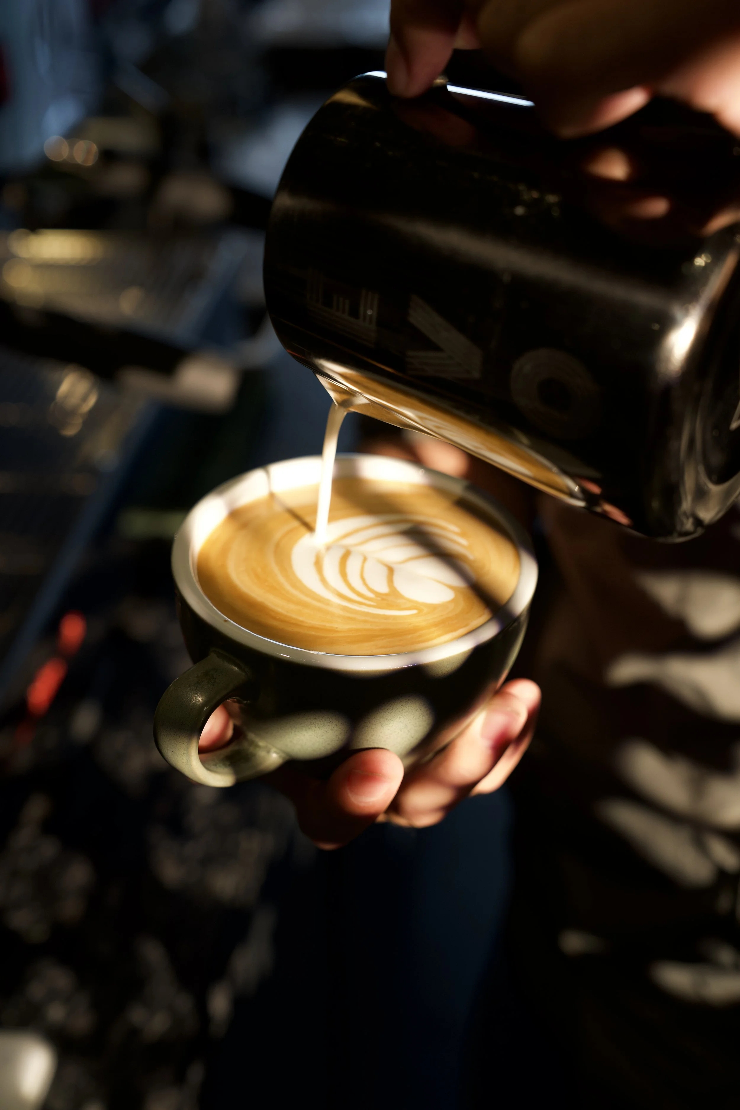 Pouring latte art into a coffee cup