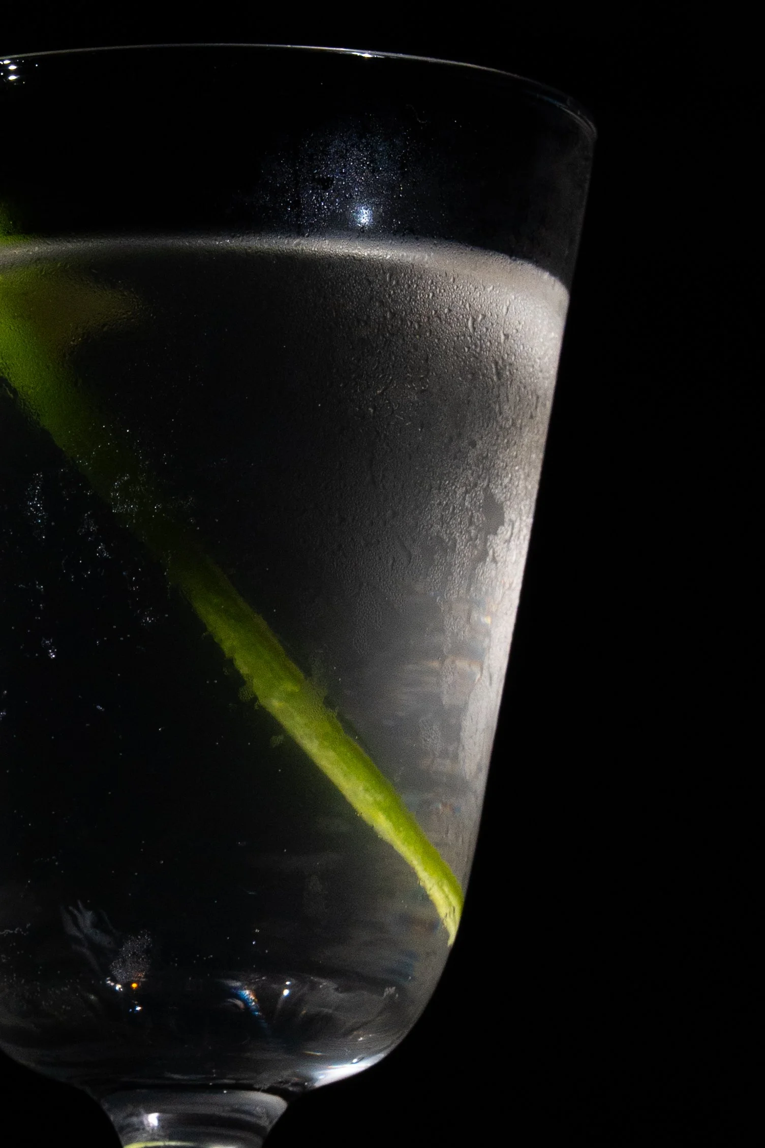 Close up of a frosty cocktail glass with a green garnish