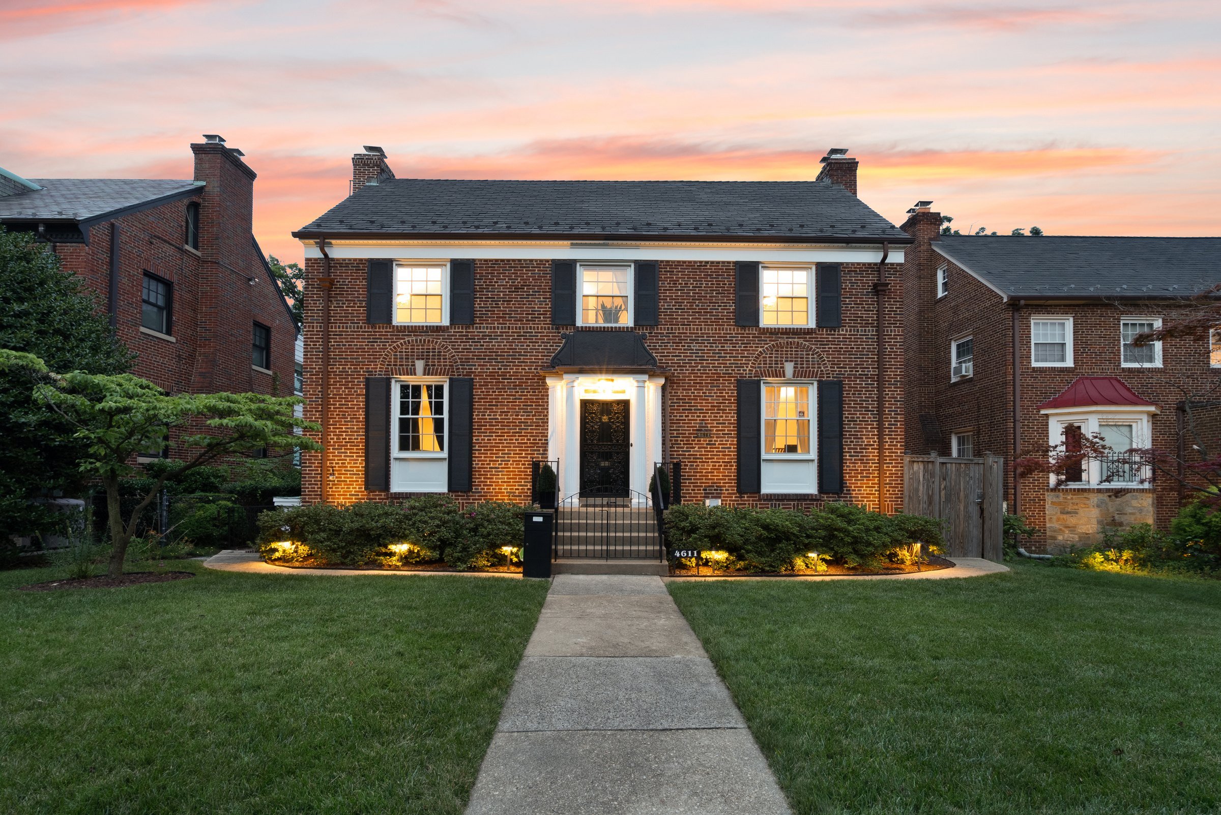 Brick colonial home at dusk at 4611 16th Street NW, Washington DC, a FORWARD at Corcoran McEnearney listing