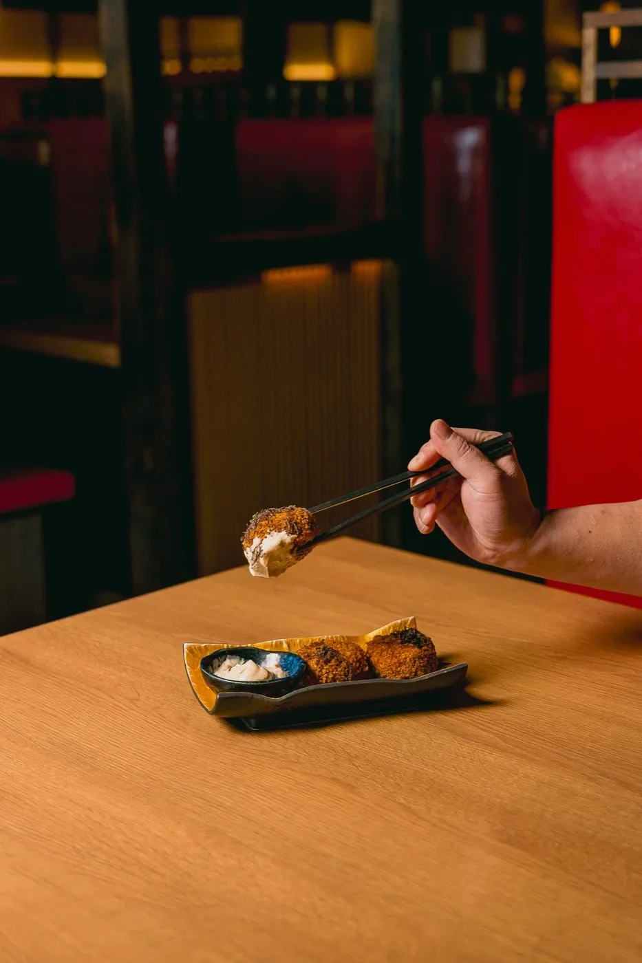 Katsu lifted with chopsticks in the dining room