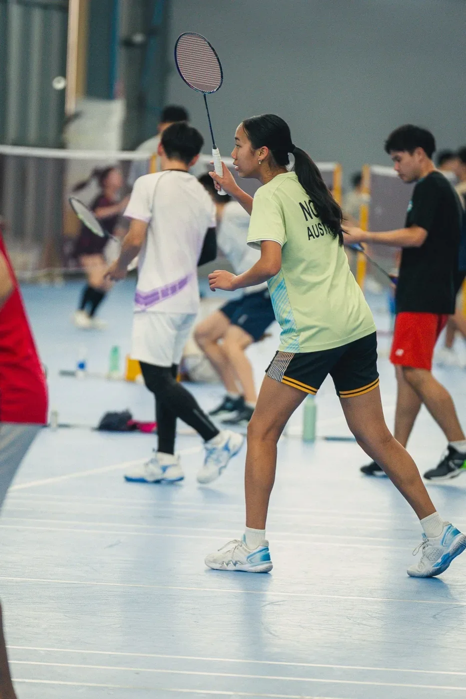 A junior player mid-rally on court