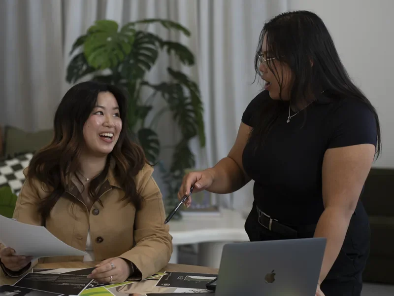 Two IRO Creative team members collaborating over design work