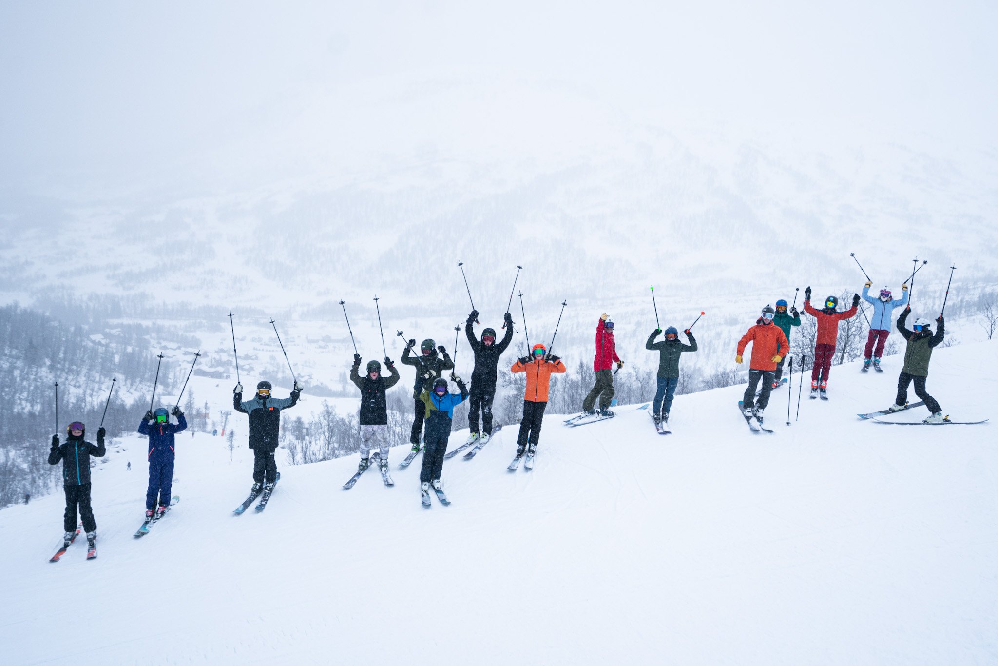A group of skiers lift their poles in the snow-covered Hodlekve