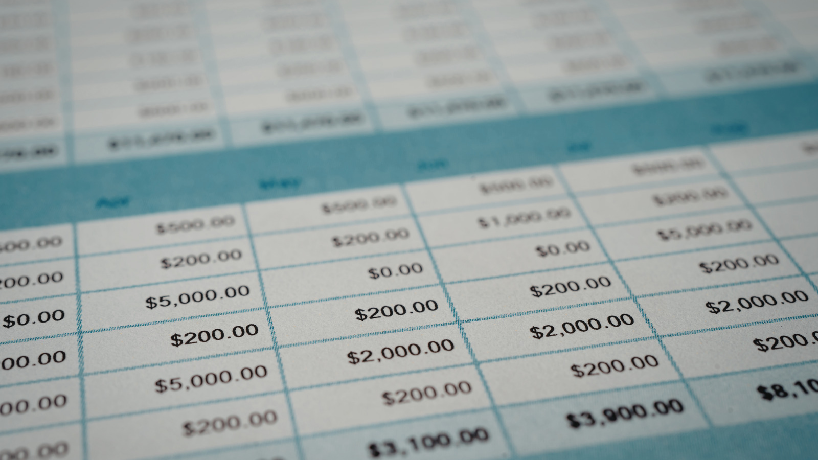 Notebook with budget calculations next to a laptop showing a spreadsheet
