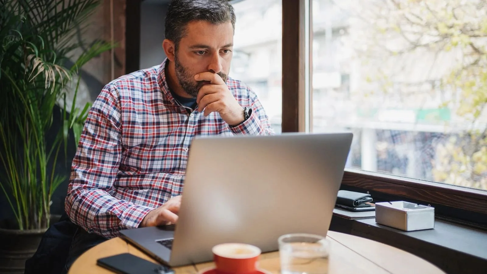 Small business owner reviewing the year's marketing at a desk with a laptop and notebook