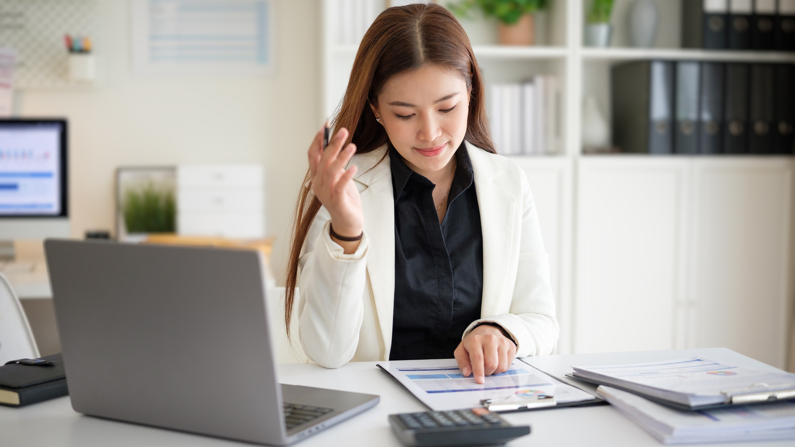 Small business owner working out next year's marketing budget with a calculator and laptop