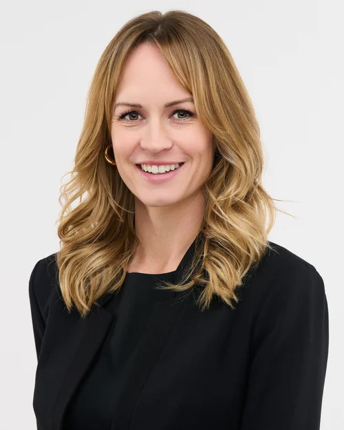 Headshot of a smiling woman with wavy blonde hair in a black top, ATX Headshots