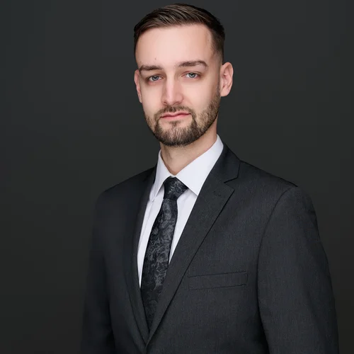 Headshot of a man in a dark suit and patterned tie against a dark backdrop, ATX Headshots