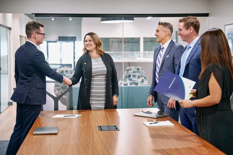 Colleagues shaking hands in a conference room, photographed on location by ATX Headshots