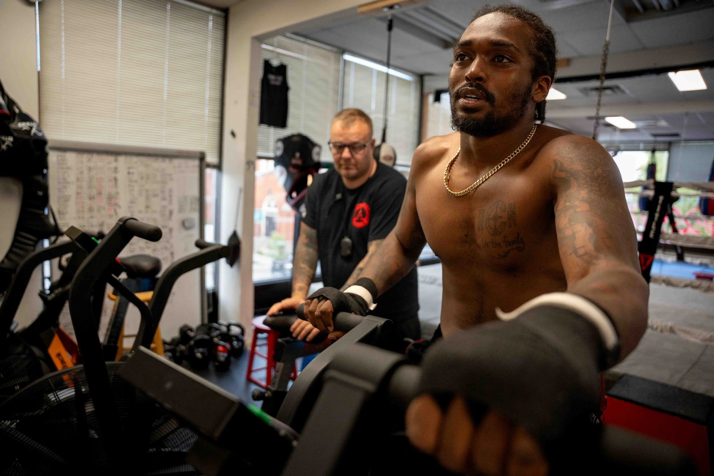Pinnacle Boxing athlete catches his breath during training at the Belleville gym, light highlighting the sweat and emotion after an intense workout.