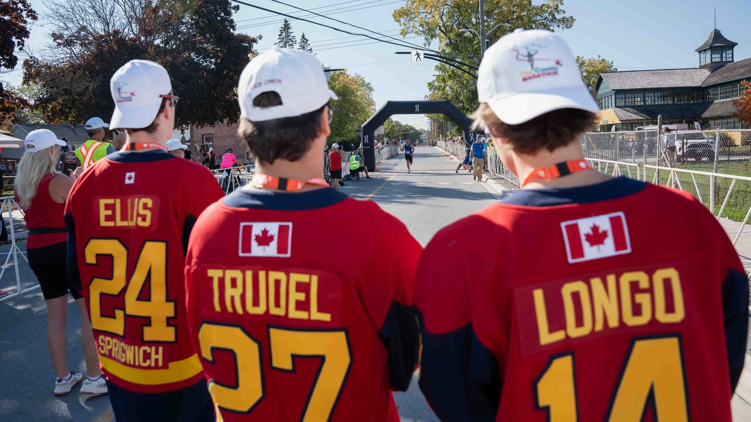 Volunteer support and race atmosphere documented at the County Marathon finish area in PEC.