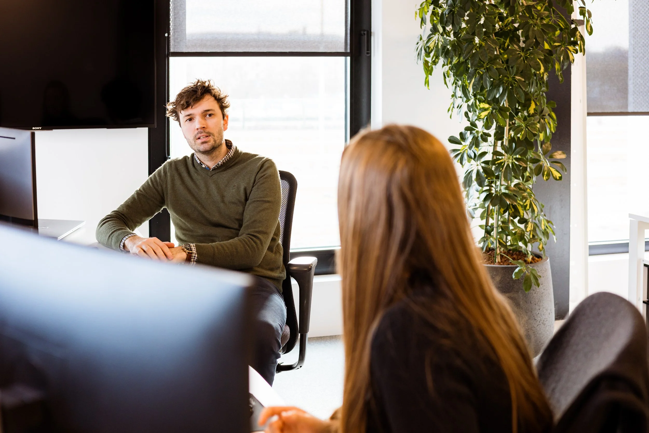 Two colleagues talking at their work space