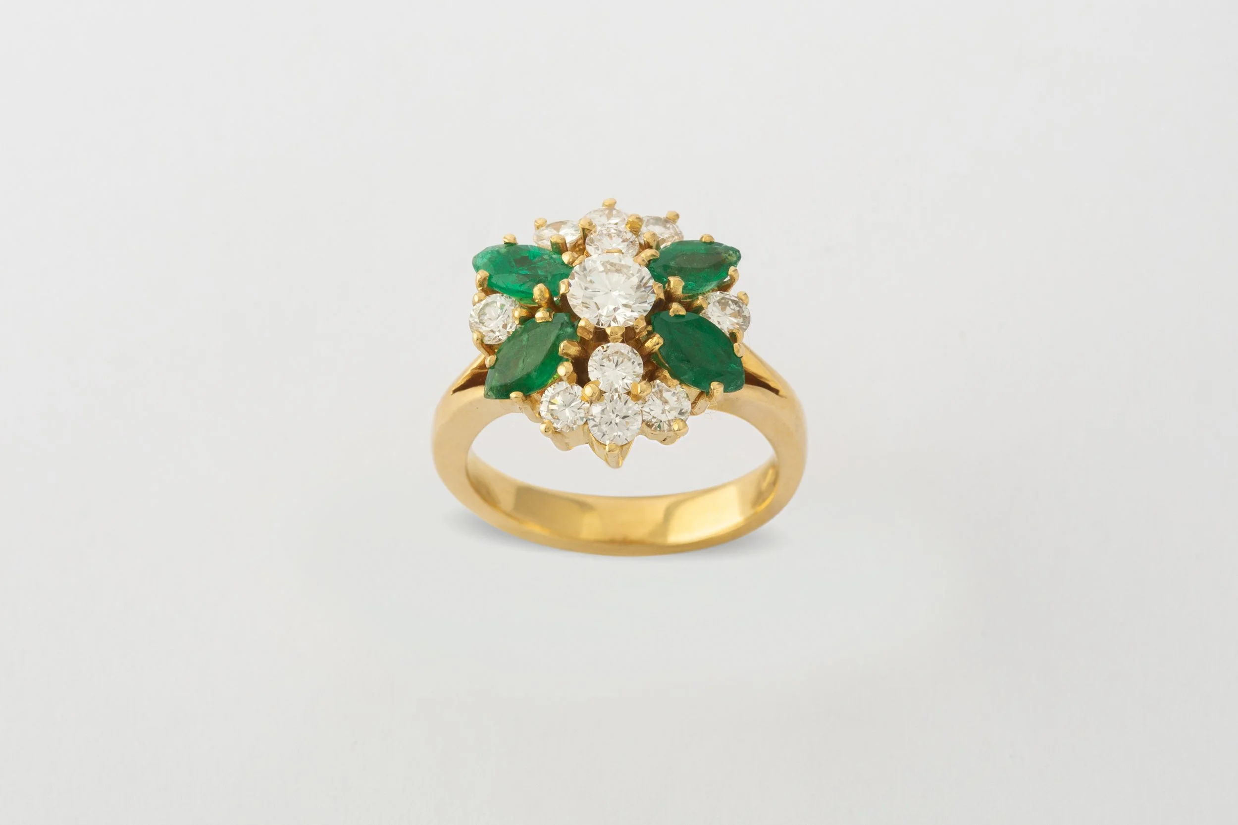 Jewellery photography of a gold ring with diamonds and emeralds