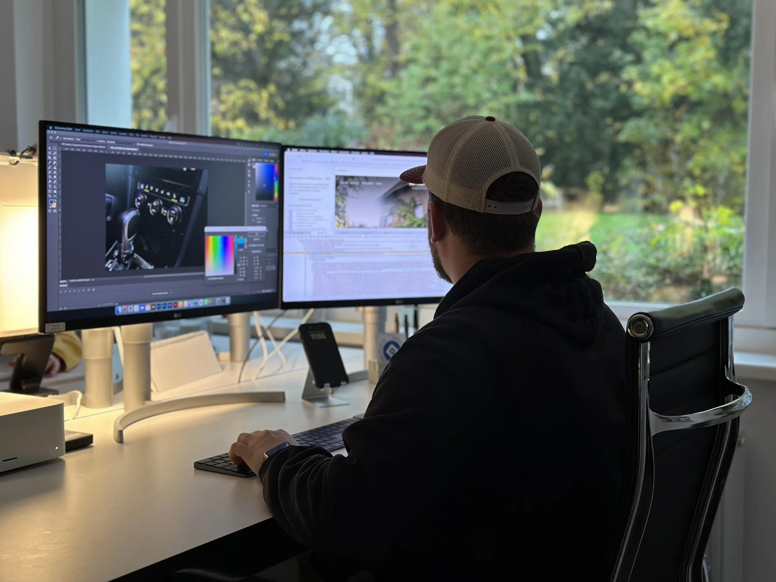 Eine Person sitzt vor zwei Monitoren und ist am Editieren einer Website.