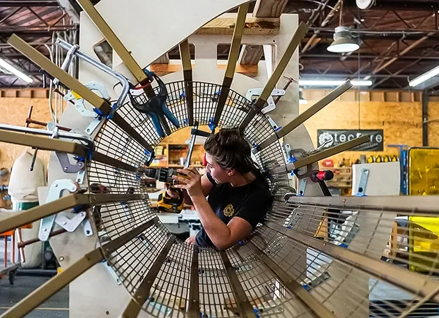 Fabricator assembling a large radial wood and steel structure in the Tecture shop.