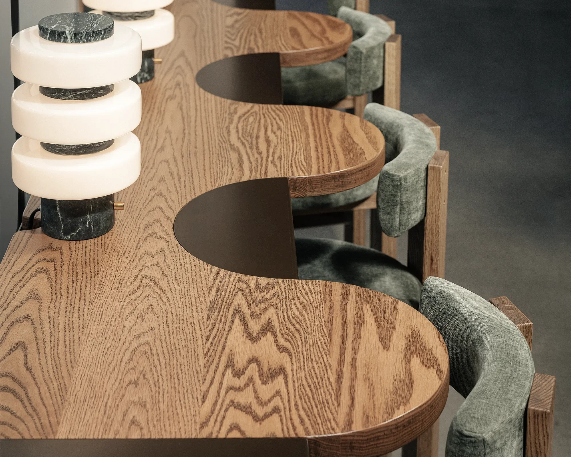 Close view of a curved white oak table edge and upholstered chair custom built for Base Pair Cafe