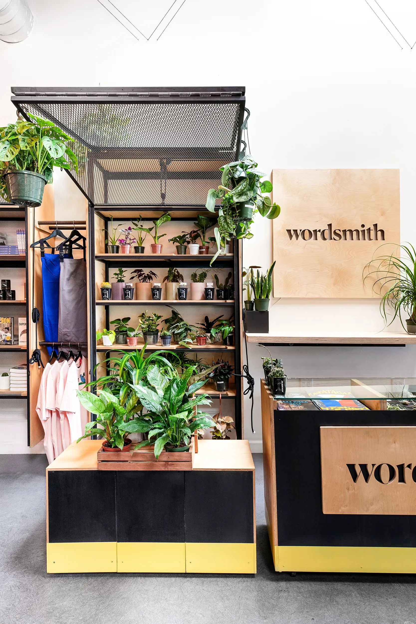 Open steel and timber millwork shelving stocked with plants and goods at Wordsmith in San Diego