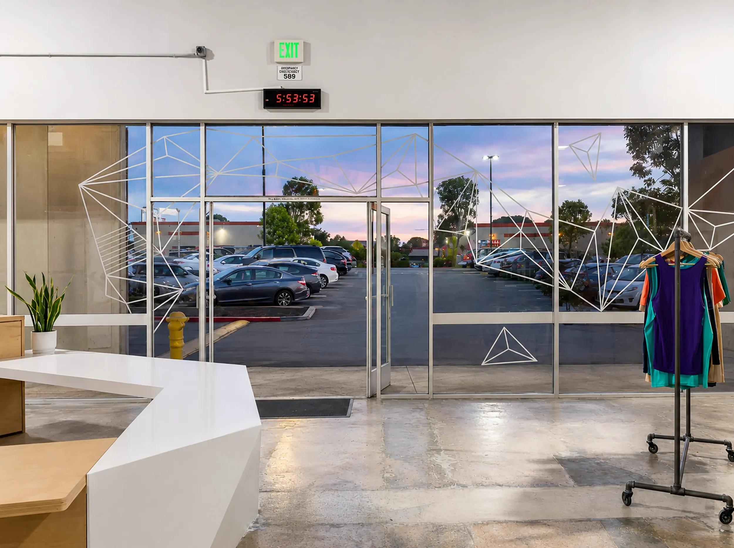 Geometric line window graphics across full height glazing behind the retail counter at the Grotto in San Diego