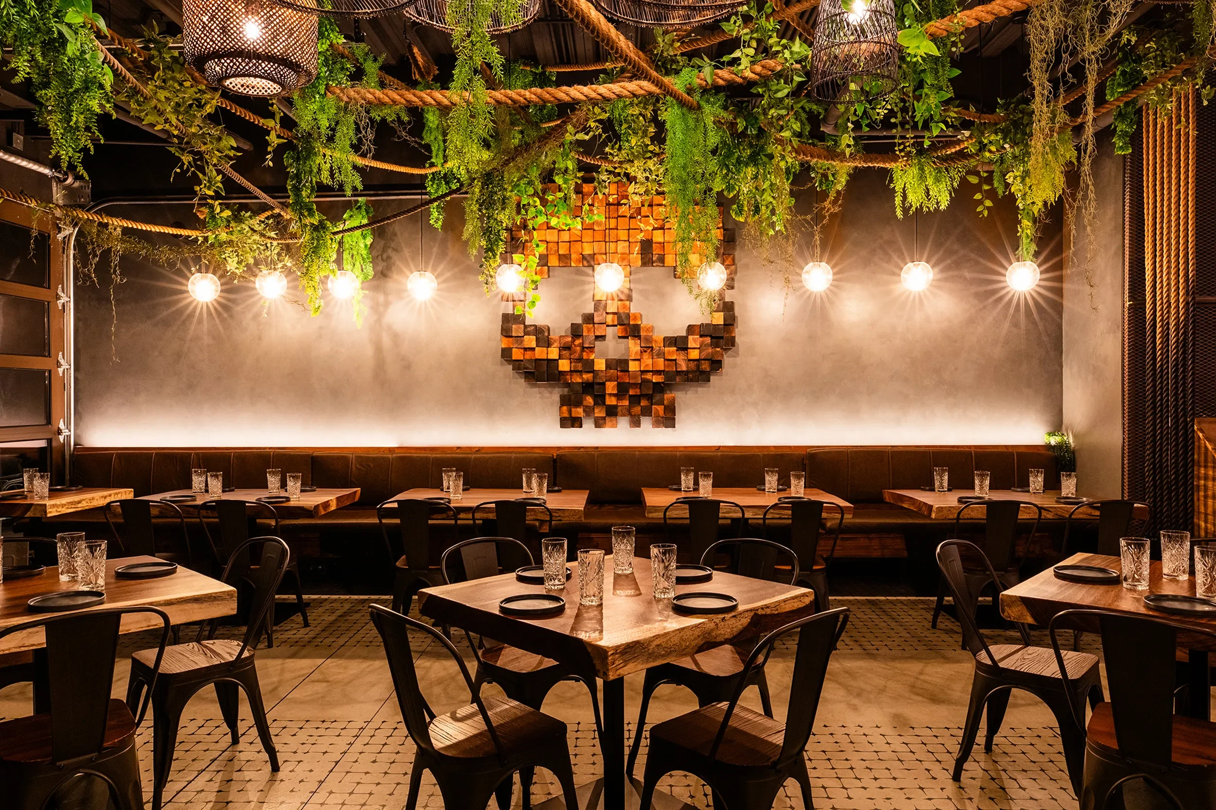 String lit dining room with hanging greenery at Craft House inside of Sky Deck in Del Mar