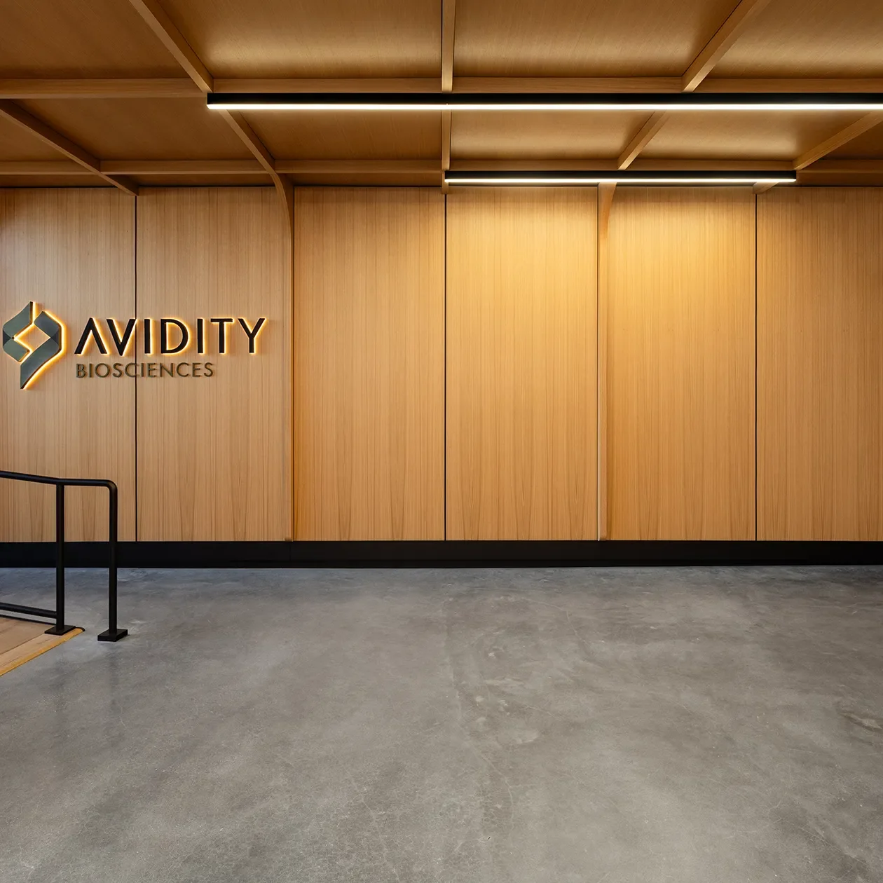 Full height wood panel wall system with integrated lighting in a finished lobby space