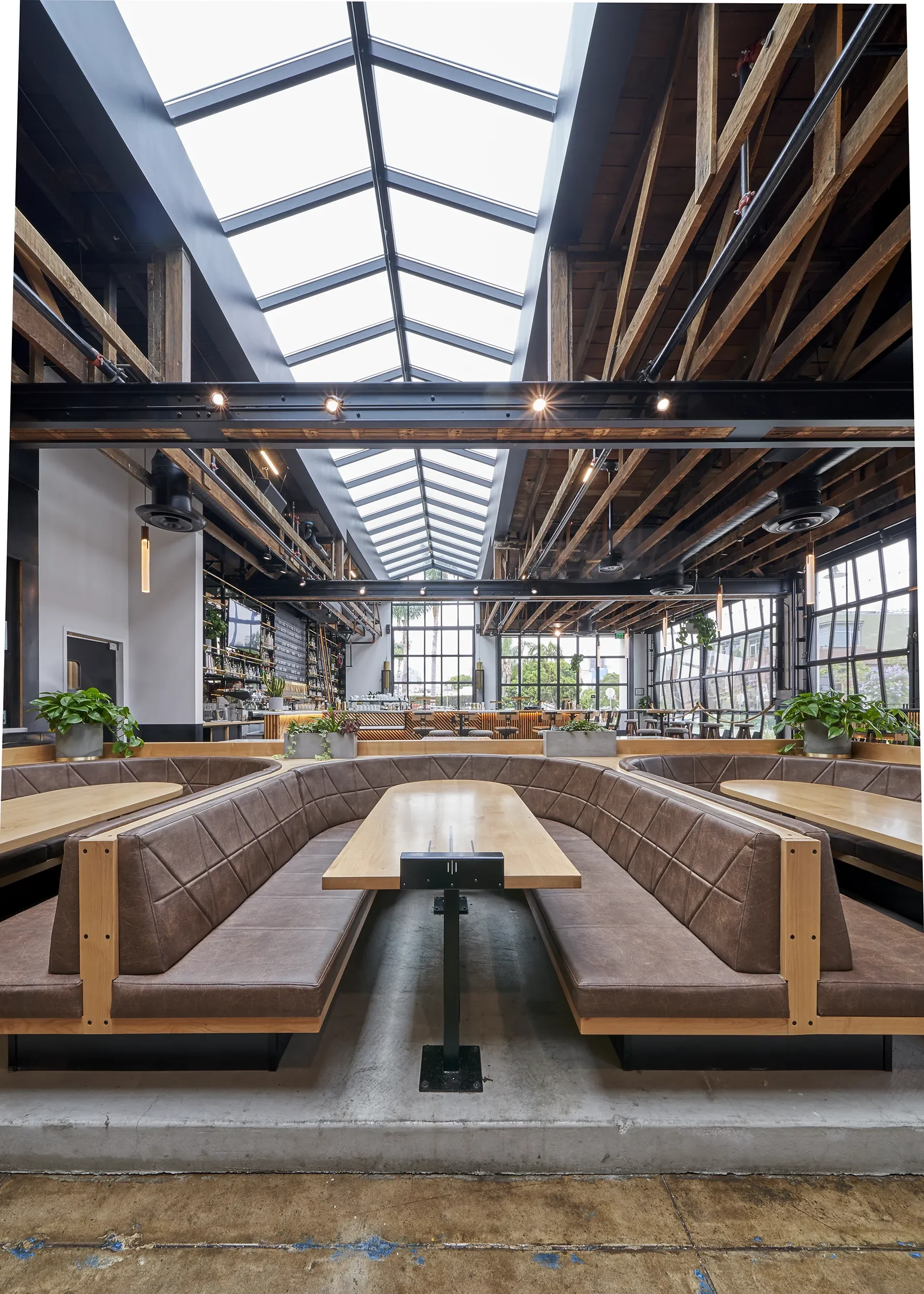 Custom communal tables and leather booth seating fabricated for Nolita Hall in Little Italy San Diego