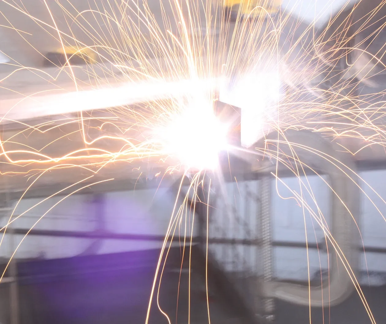 Sparks flying from a steel cut on the fabrication shop floor at Tecture in San Diego
