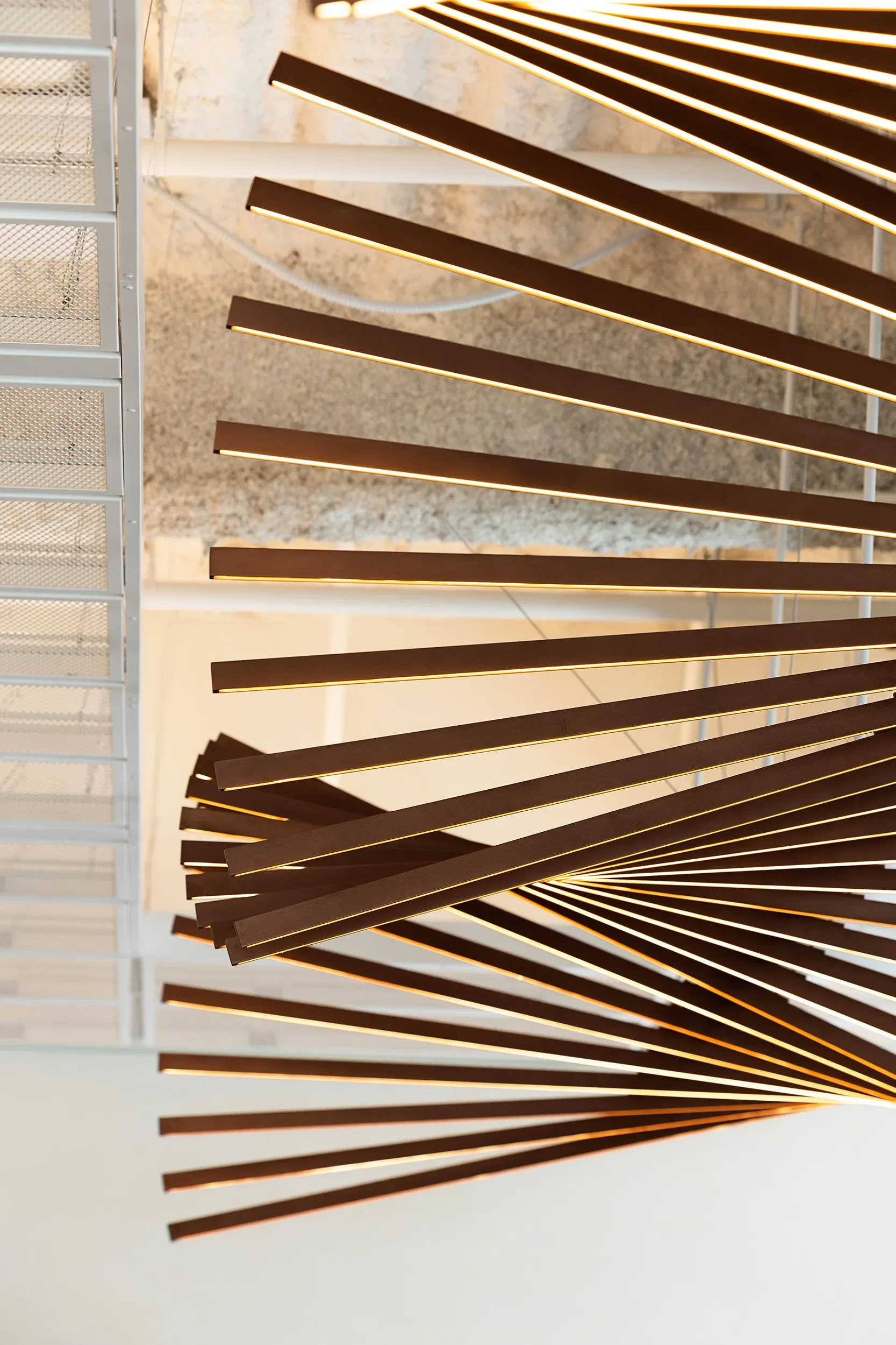 Detail of flat bronze rods and linear lighting in a custom sculptural fixture